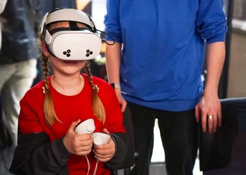 Child using virtual reality headset and controllers, immersed in a digital .. Foto stock