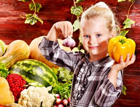 Child with vegetable on kitchen. Stock-Fotos