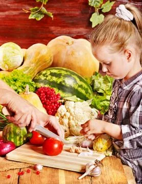 Child with vegetable on kitchen. Foto stock