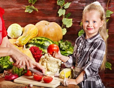 Child with vegetable on kitchen. 스톡 사진