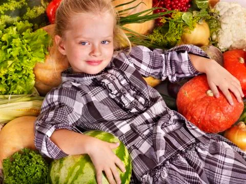 Child with vegetable on kitchen. Stock Photos