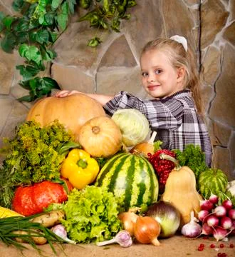 Child with vegetable on kitchen. Foto stock