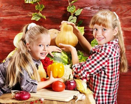Child with vegetable on kitchen. Stock-Fotos