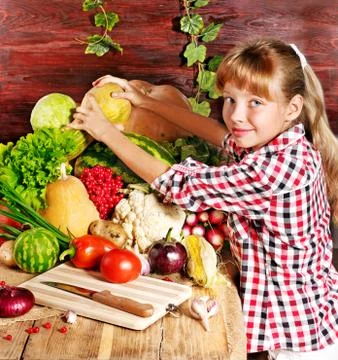 Child with vegetable on kitchen. 스톡 사진
