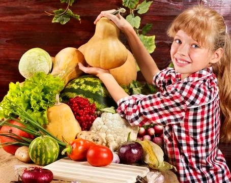 Child with vegetable on kitchen. Foto stock