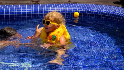 A child in a vest swims in the pool. Selective focus. Stock Footage 262962847