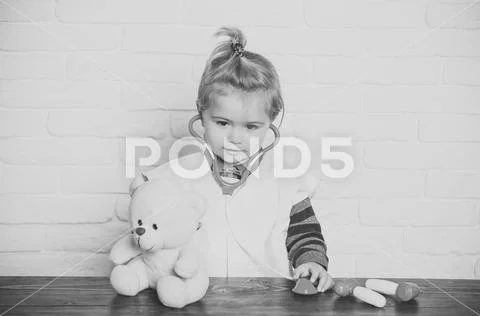 Child veterinarian examine teddy bear with stethoscope Stock Photos