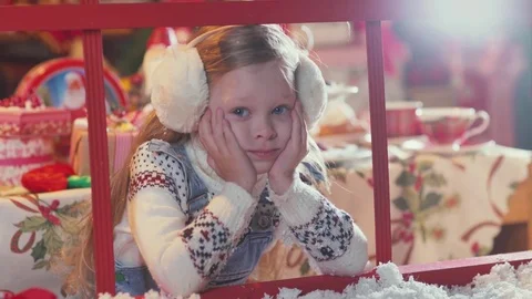 A child waiting for Christmas and Santa Claus looking out the window Stock Footage