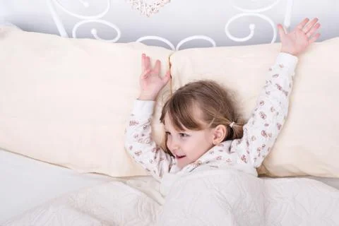 Child wakes up in bed Stock Photos