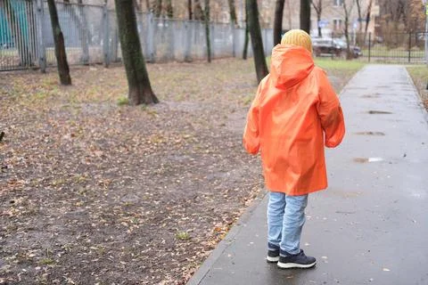 Child walking alone on wet path in autumn park 스톡 사진