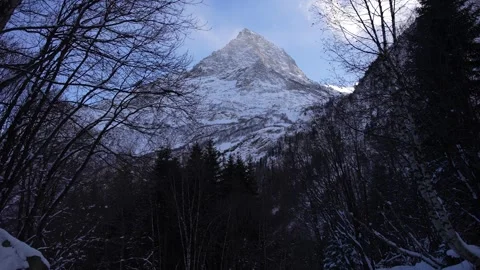 Child walking along a snowy path in a mountain valley Stock Footage 310230607