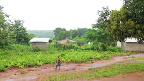 Child walking on a dirt path on a rainy day Stock Footage 77443951