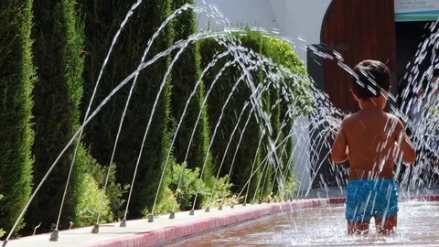 Child walking inside a fountain Stock Footage