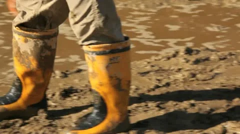 Child walking in mud with gumboots. Stock Footage 10864837