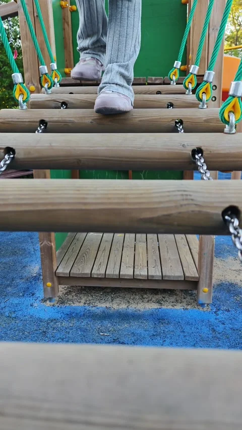 Child walking on playground bridge Stockbeeldmateriaal 310250637