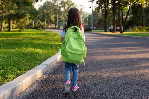 Child walking to school with backpack on a sunny day Stock Photos
