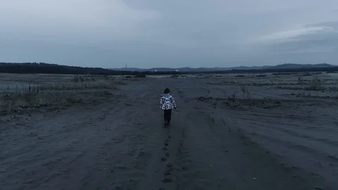 Child walking through an empty, desolated land. Aerial, drone video. Slow motion Video stock 122515790