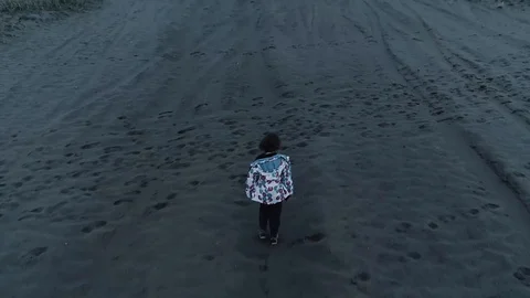 Child walking through an empty, desolated land. Aerial, drone video. Slow motion Stock Footage 122515839