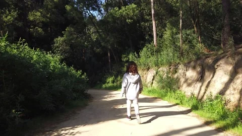 Child walking through a forest or a park with green leaves Video stock 134837281