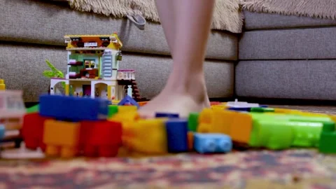 The child walks among the scattered cubes. Mess in the children's room Stock Footage 241930888