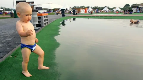 A Child Walks Barefoot Through a Puddle Stock Footage 64764686