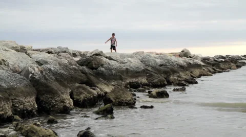 Child walks on the beach breakwaters Stock Footage 65118042