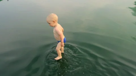 A Child Walks Through a Puddle Stock Footage 64764980