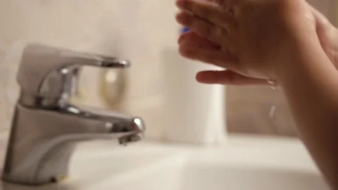The child washes hands with soap over a white sink during quarantine covid 19 Видео 132354739