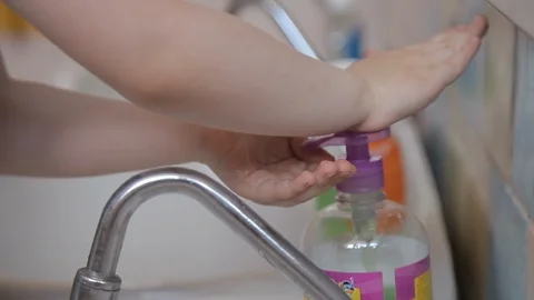 Child washes his hands with liquid soap under the tap with water. Stock Footage 110919881