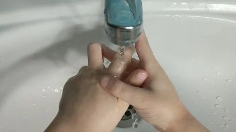 A child washes his hands under the tap in the bathroom over the ceramic white 스톡 동영상 152178521