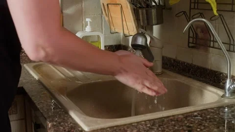 Child washing hands in kitchen sink with running water 库存影片 345060379