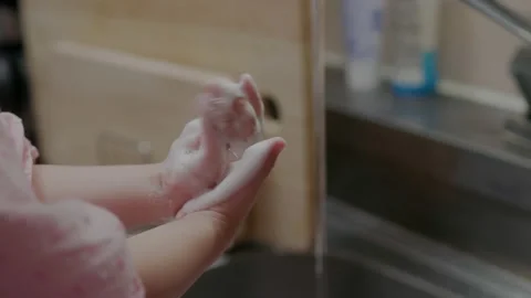 Child washing hands in steel sink Stock Footage