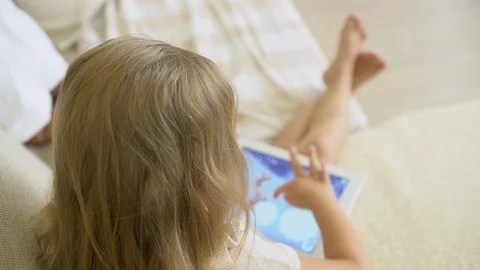 Child watching ang using tablet at home. Children using a modern laplop, tablet Stock Footage 96498860