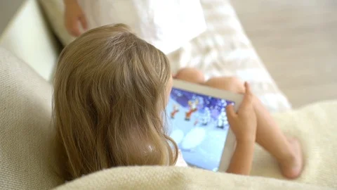 Child watching ang using tablet at home. Children using a modern laplop, tablet Stock Footage 96499326