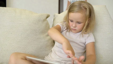 Child watching ang using tablet at home. Children using a modern laplop, tablet Stock Footage 96500518