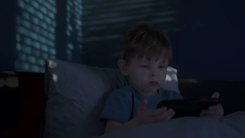 Child Watching Smartphone Screen in Bed at Night Stock Footage 317234538
