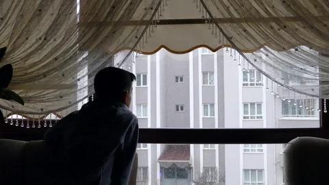 Child watching snowfall through the window, snowfall view through the window, Stock Footage 123873605
