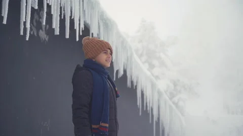 Child watching the view in front of icicles. Vídeo Stock 167541252