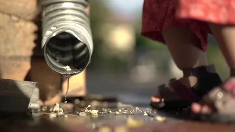 Child at the water drain Stock Footage 77804889