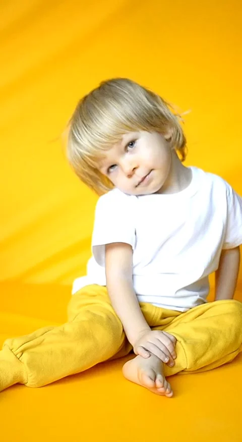 The child waves his hand and shows hello or bye. The kid is 2 years old with Stock Footage 276523698