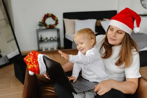 A child waves through a laptop camera on Christmas Eve. Communicating over the 库存照片