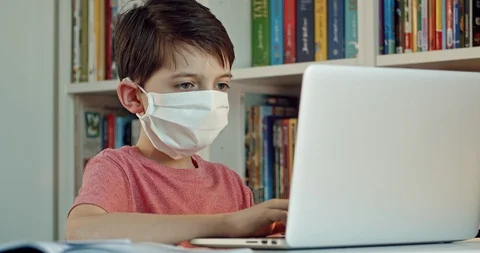Child wearing face mask learning at home. Stock Footage 126854476