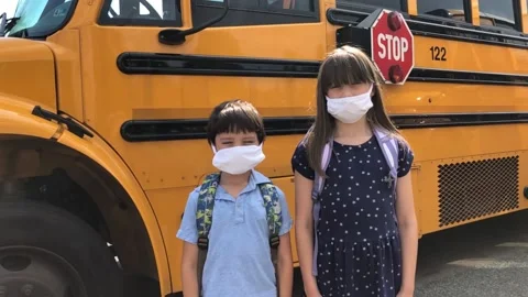 Child wearing face mask by school bus to avoid coronavirus covid19 023 Stock Footage