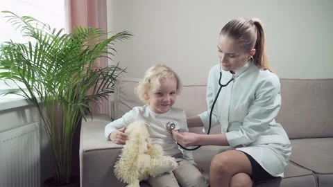 Child while the doctor examines him, listens to his breath with a phonendoscope. Vídeos de archivo 135351762