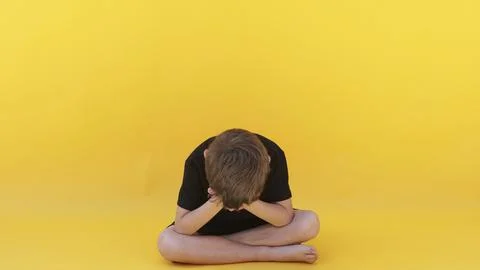 A child whose depression is sitting on the color floor Stock Photos