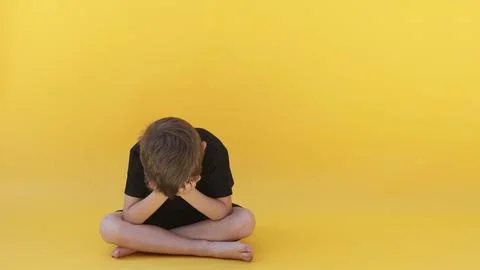 A child whose depression is sitting on the color floor Stock Photos