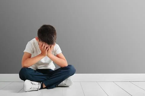 A child whose depression is sitting on the floor Stock Photos