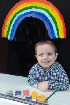 The child in the window painted a rainbow Fotos de archivo