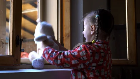 Child by the window with teddy bear. Video stock 128812861