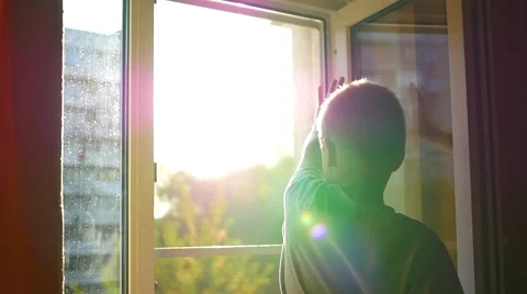 The child at the window waving in the sun 库存影片 67383501